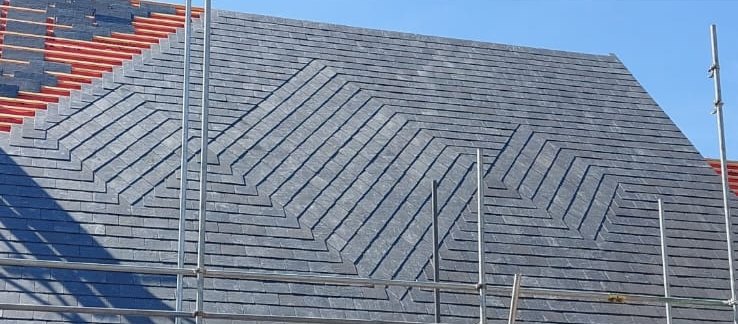 Natural slate roof laid with a decorative diagonal pattern across the slope, with scaffolding in front